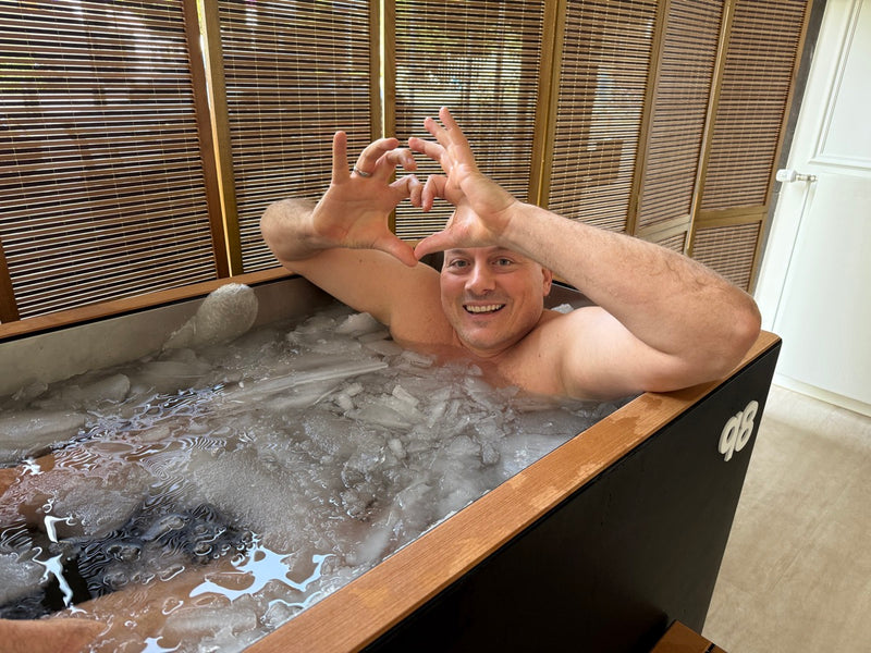 Besucher formt ein Herz mit den Händen im qoob8 Eisbad mit echtem Eis im Showroom Düsseldorf